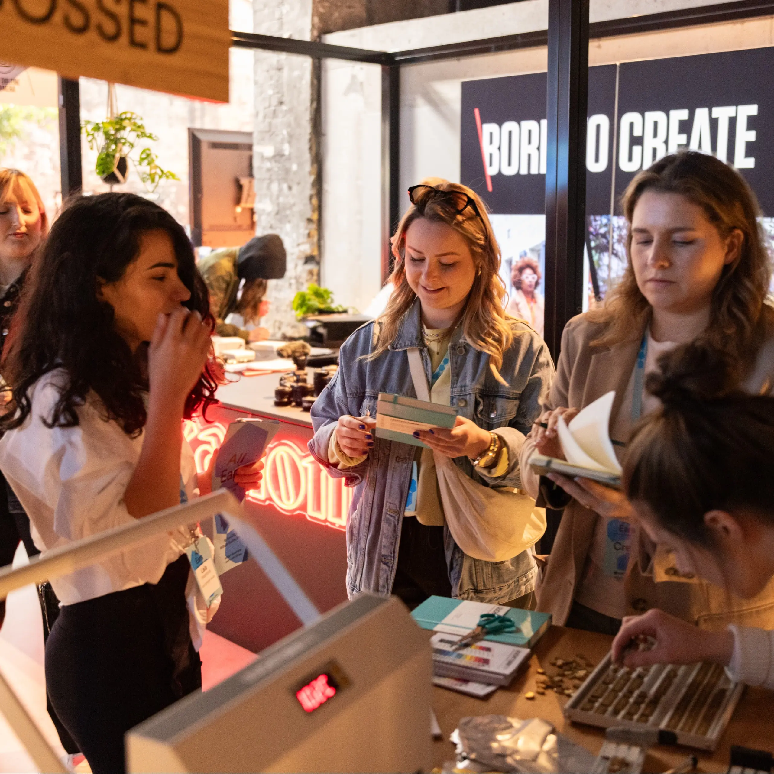 Una persona elige letras para estampado en relieve del nombre, otras miran libretas.
